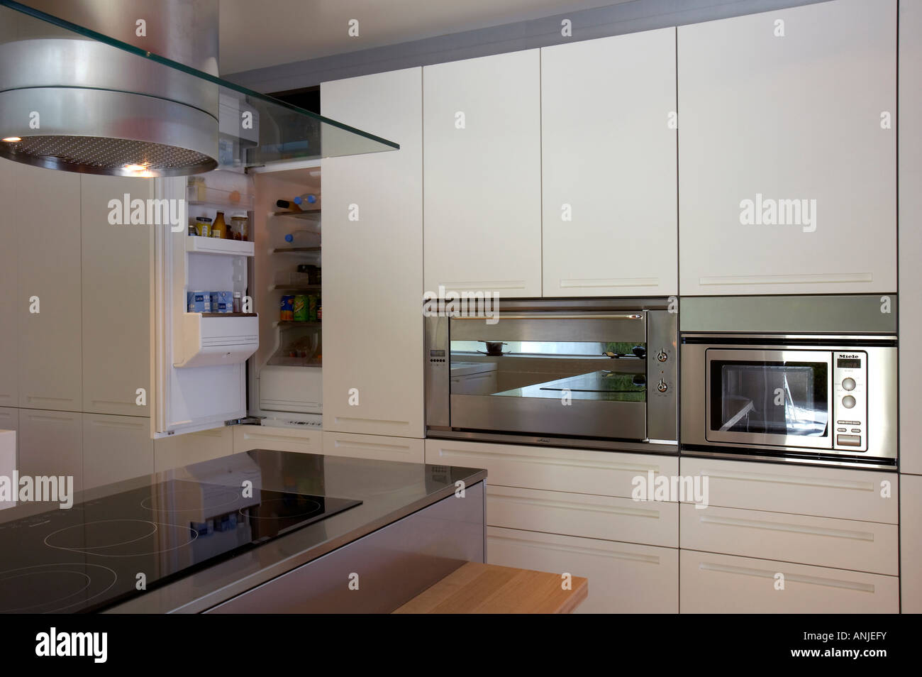 Kitchen with vent over stove top and countertop and built in refrigerator Stock Photo