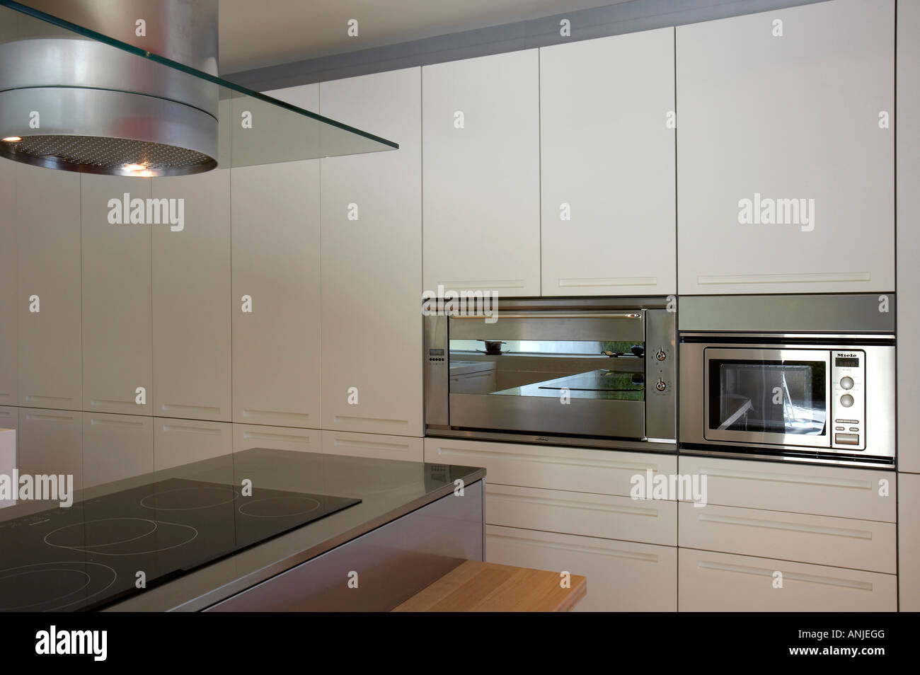 Kitchen with vent on stove top and white cabinets Stock Photo
