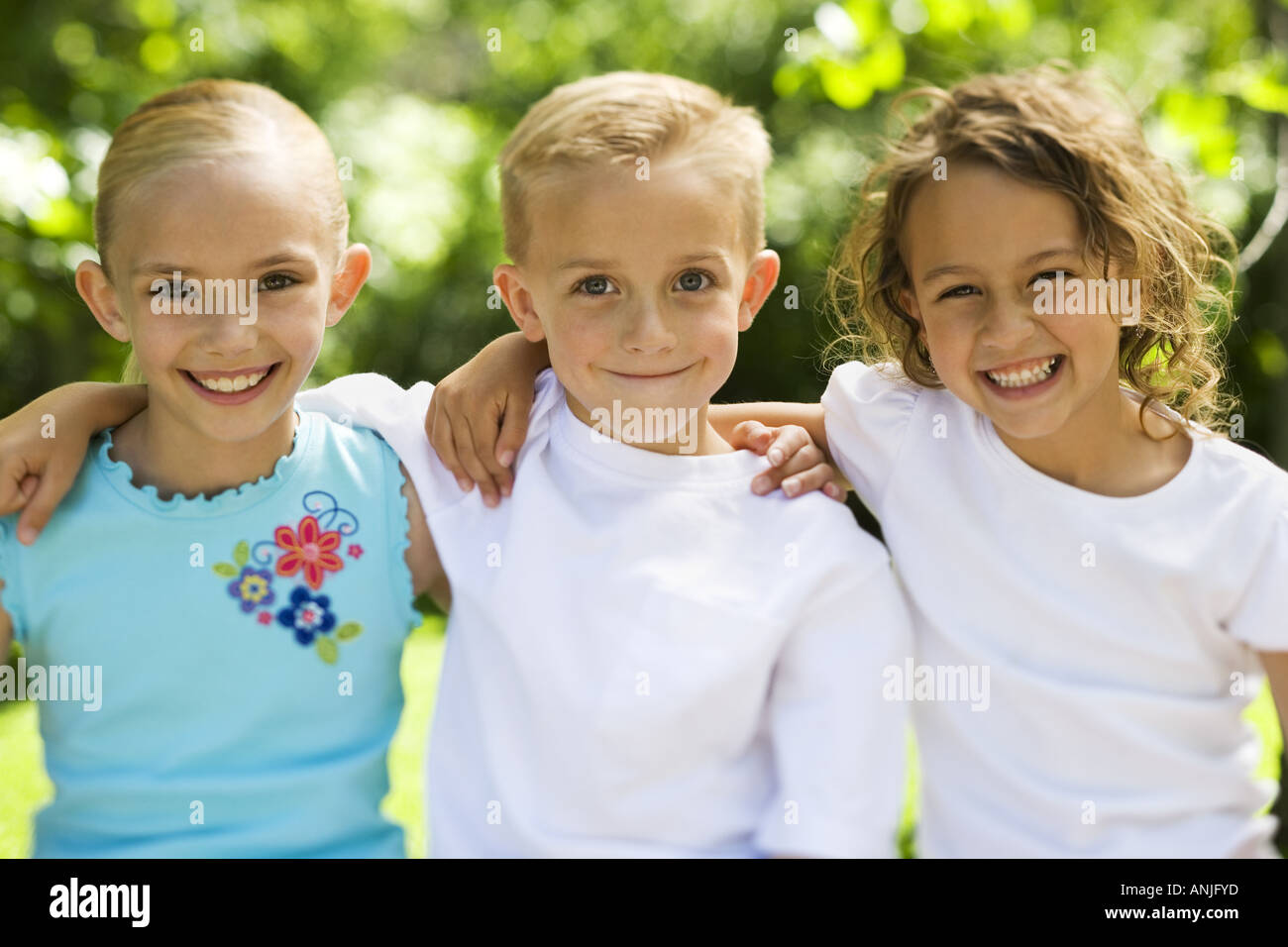 Portrait of two girls and a boy standing with their arms around Stock ...
