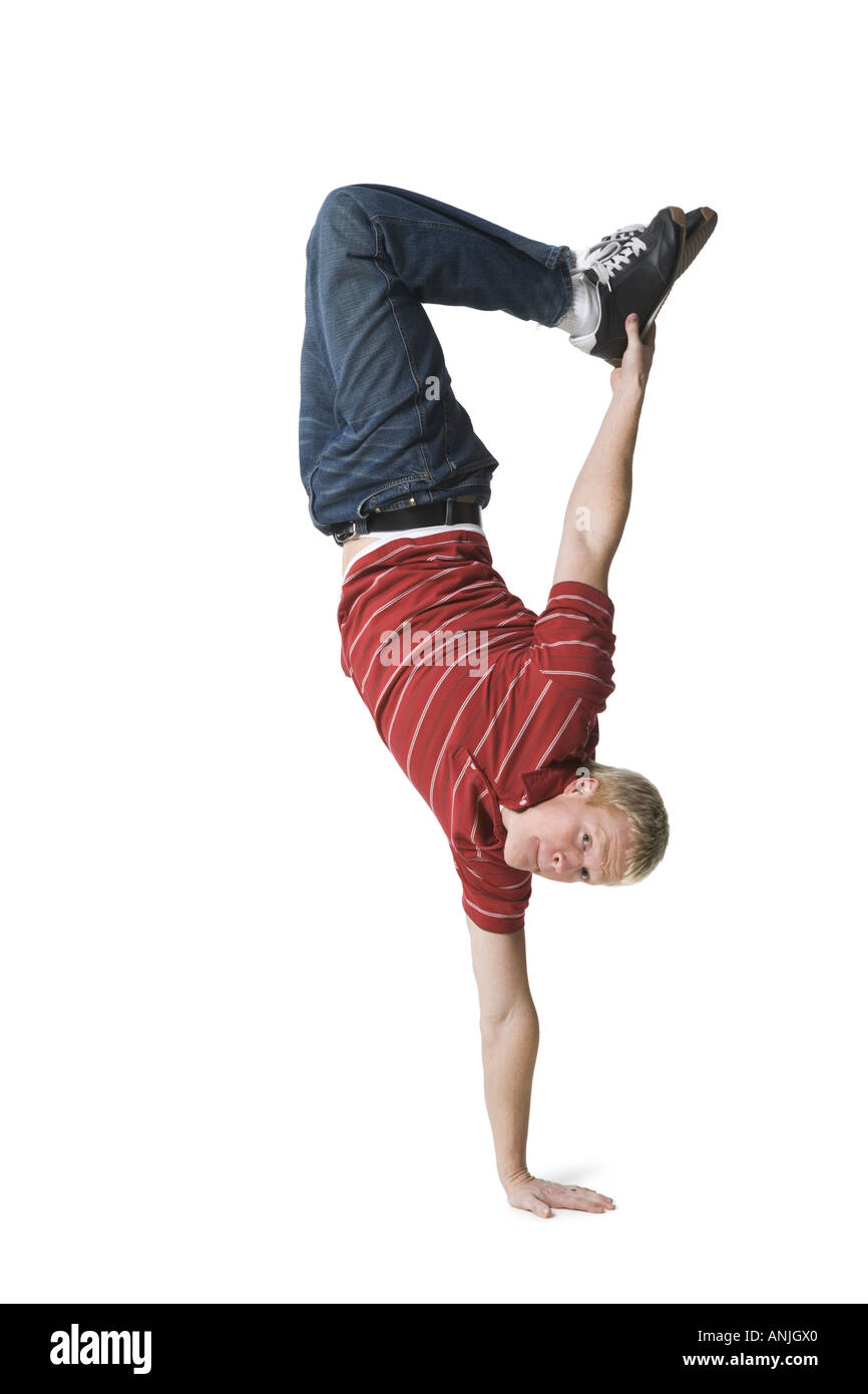 Portrait of a young man doing one handed handstand Stock Photo