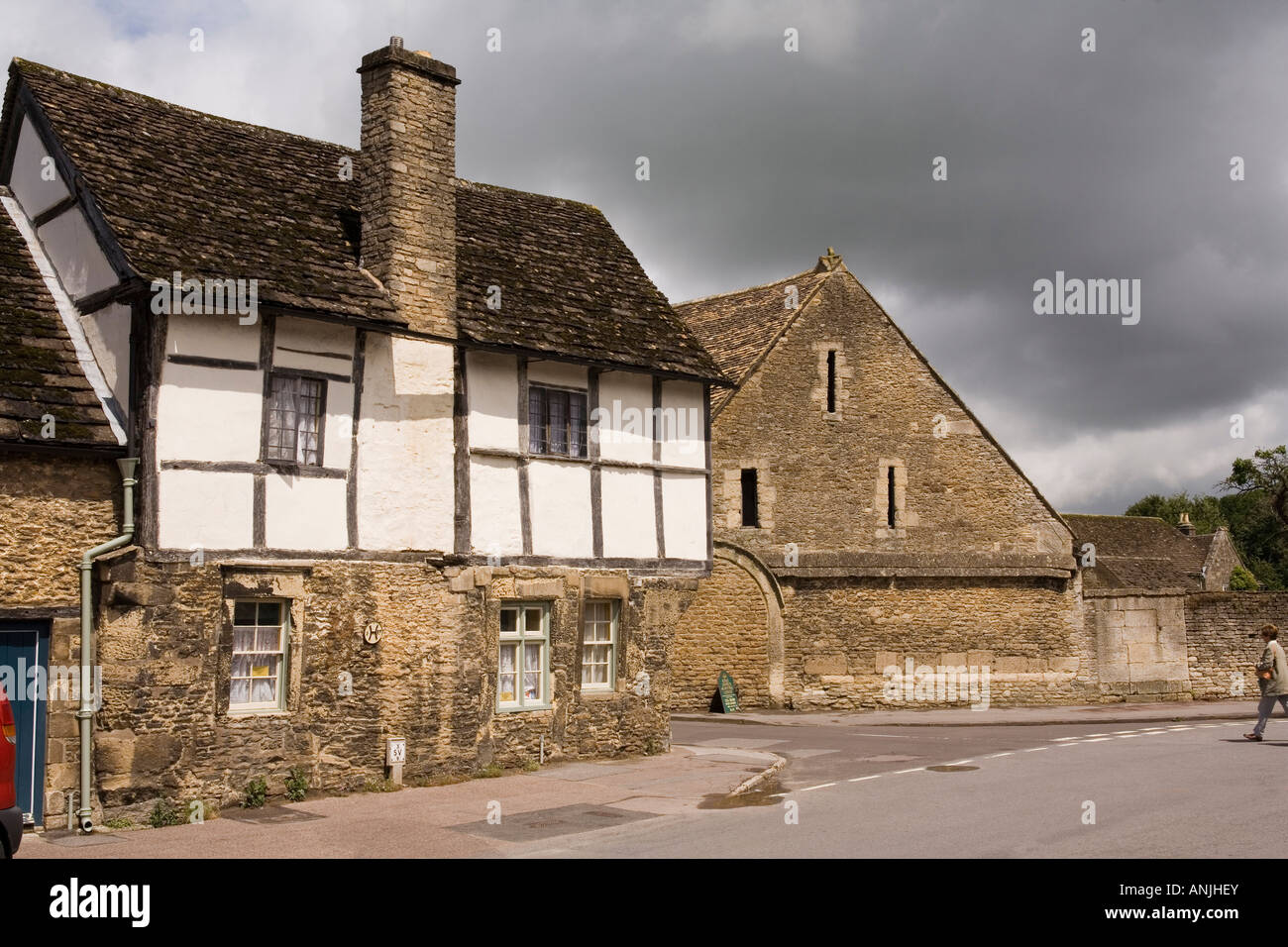 UK Wiltshire Lacock village High Street medieval Tithe Barn at East Street junction Stock Photo