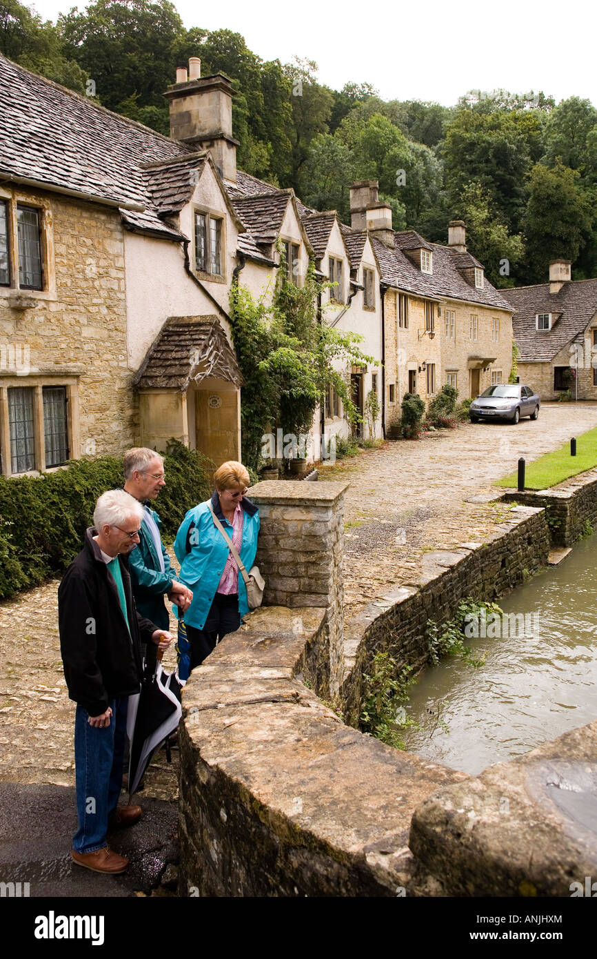 UK Wiltshire Castle Combe High Street visitors on old bridge over ...
