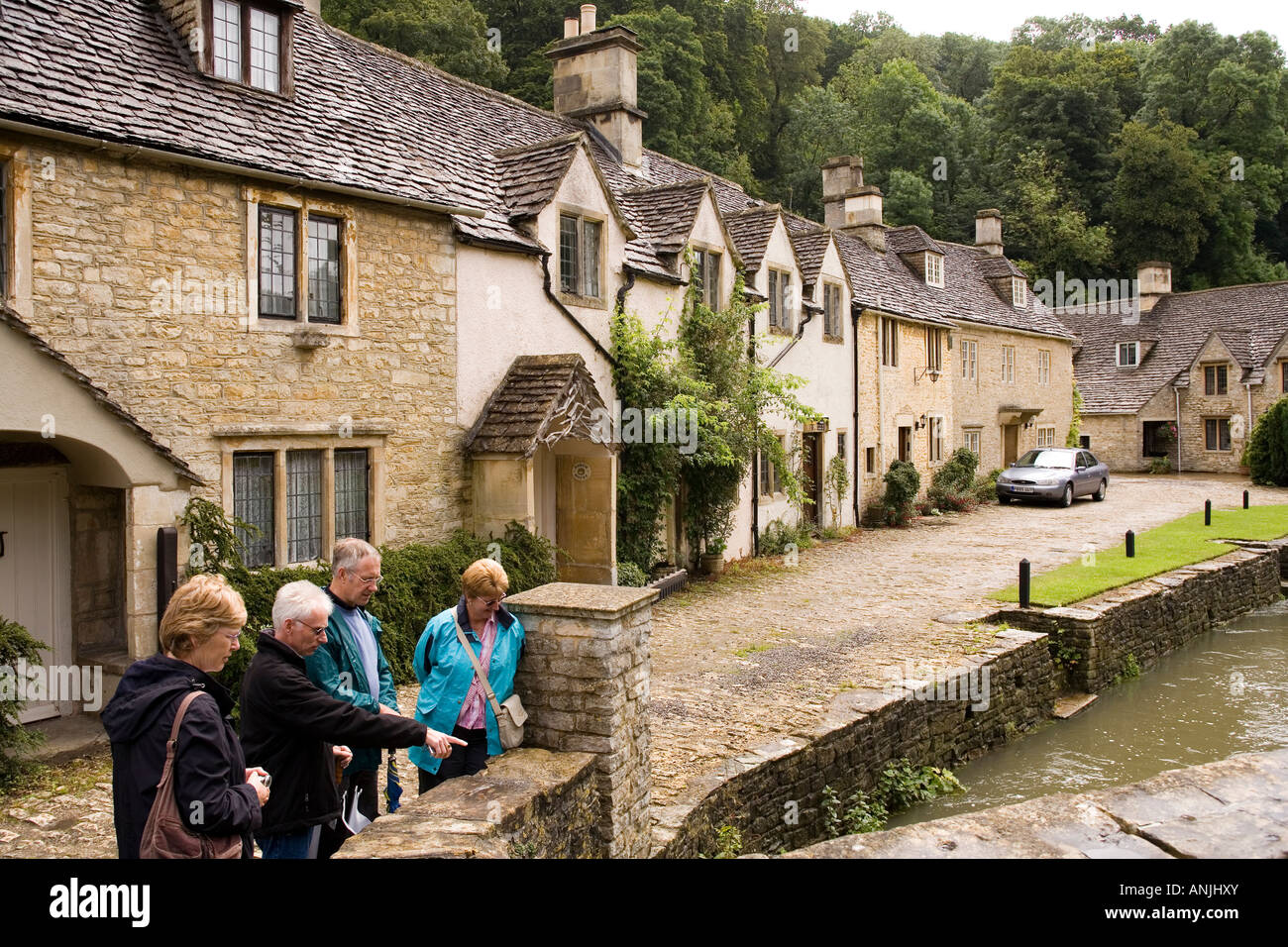 UK Wiltshire Castle Combe High Street visitors on old bridge over ...