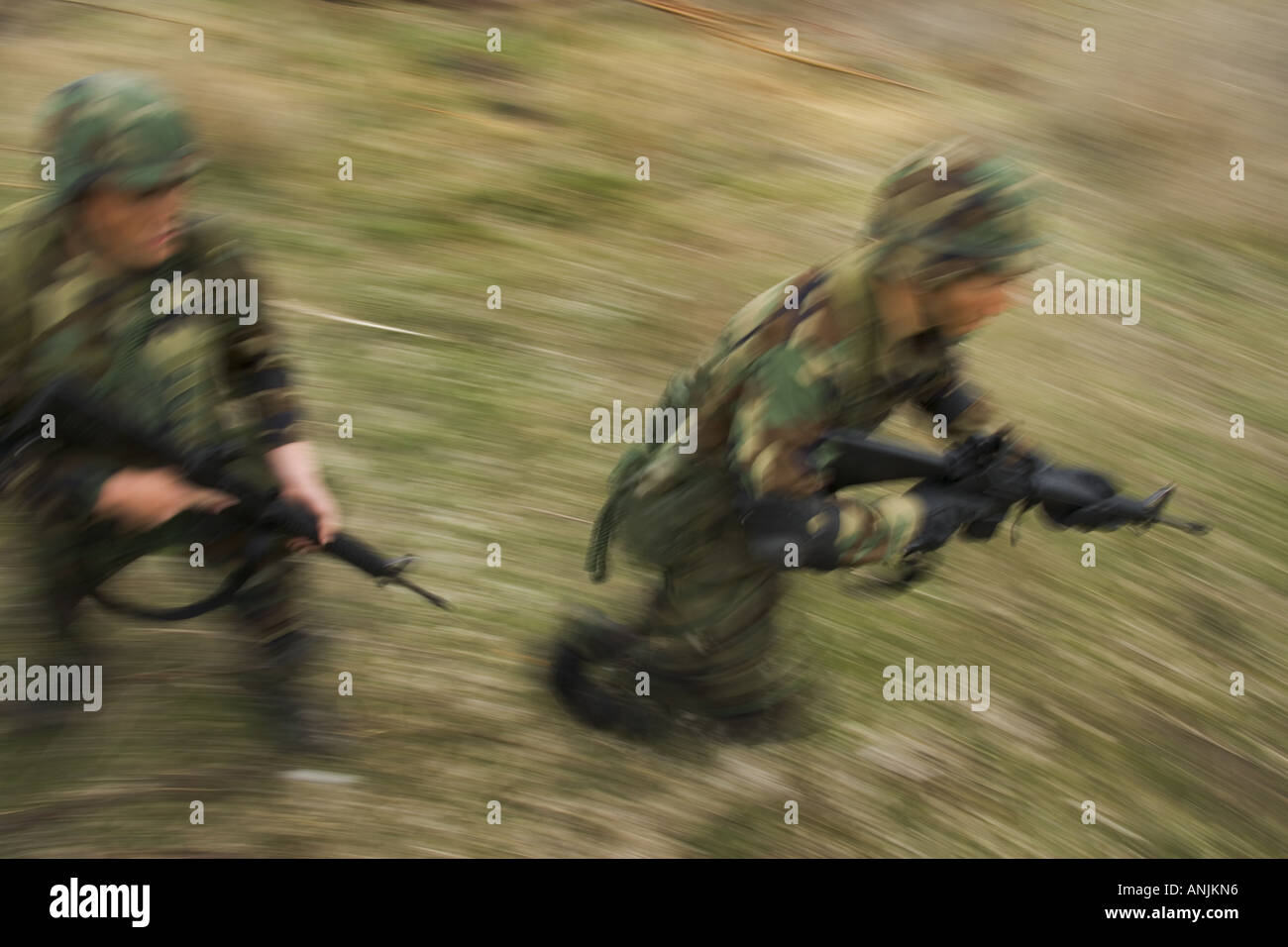 High angle view of two soldiers running on a field with their rifles Stock Photo