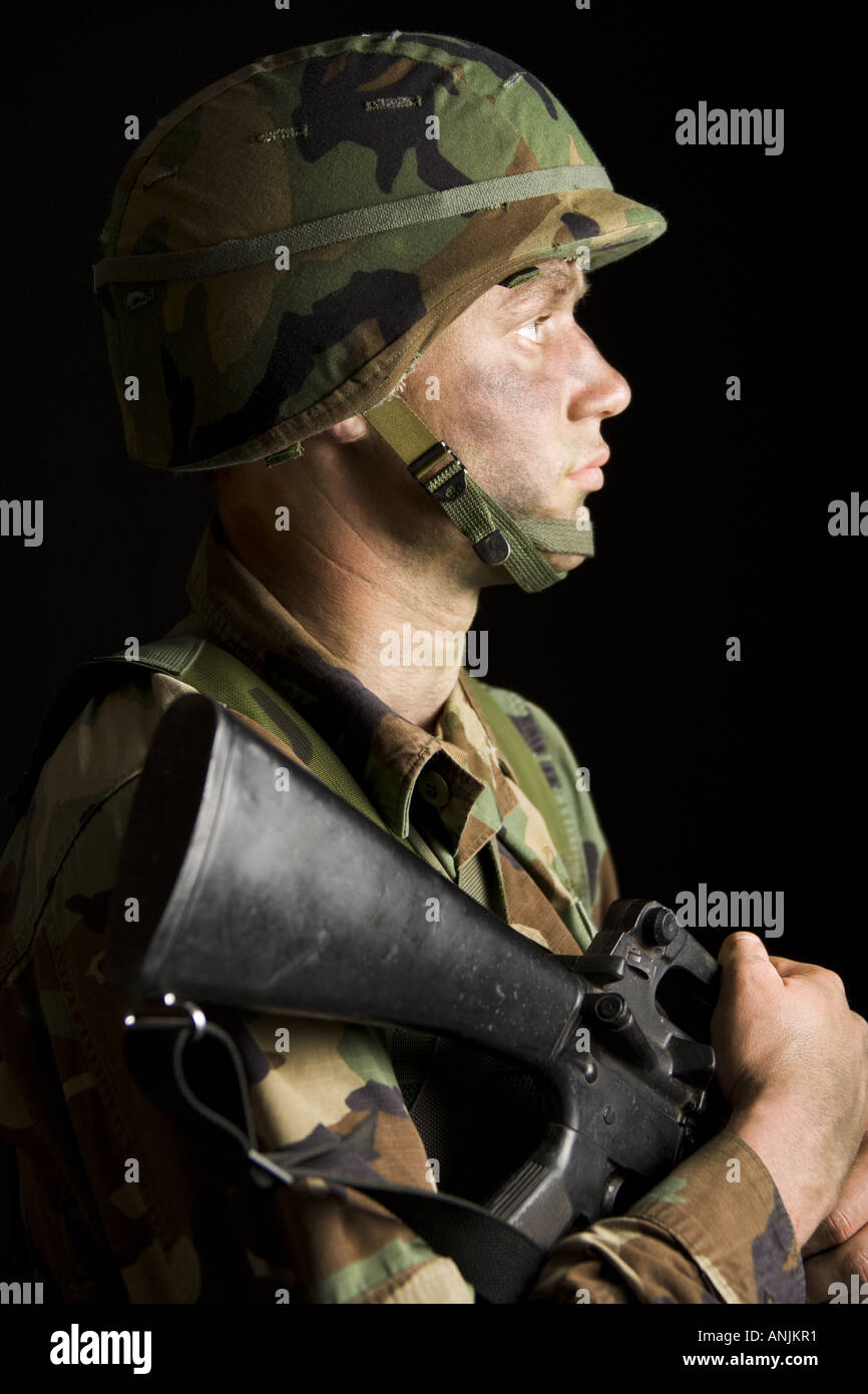Side profile of a soldier holding a rifle Stock Photo