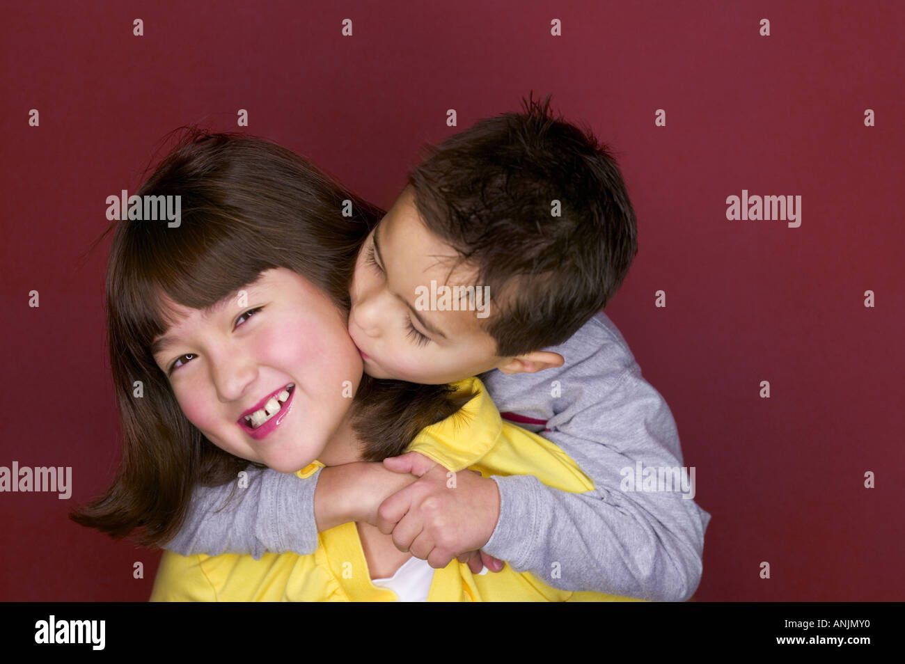 Portrait of a sister being kissed by her brother Stock Photo