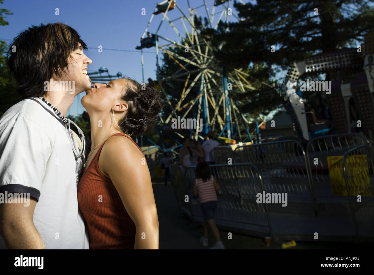 Side profile of a young woman kissing a young man Stock Photo - Alamy