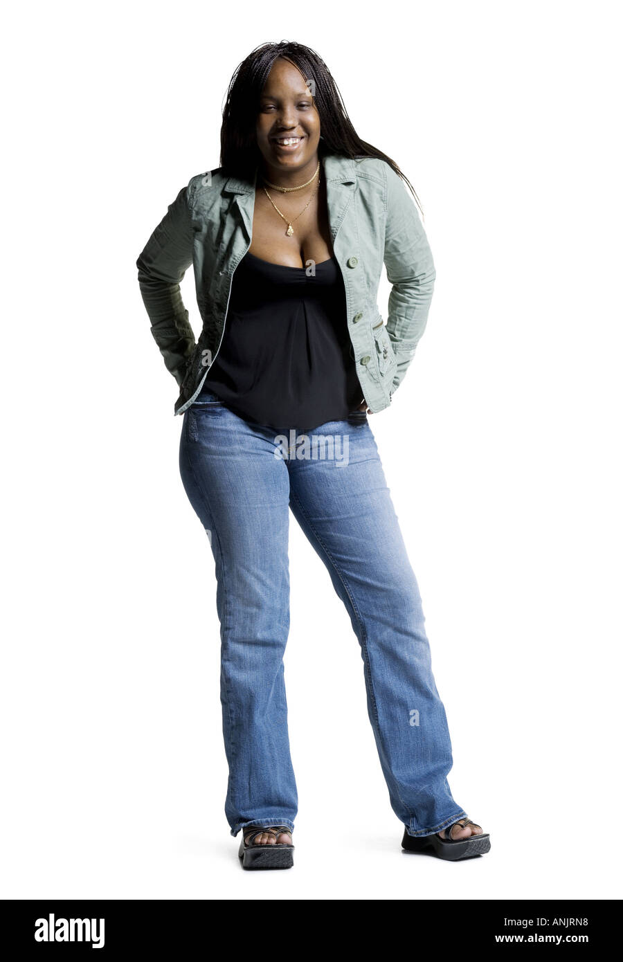 Portrait of a young woman standing with her hands behind her back Stock ...