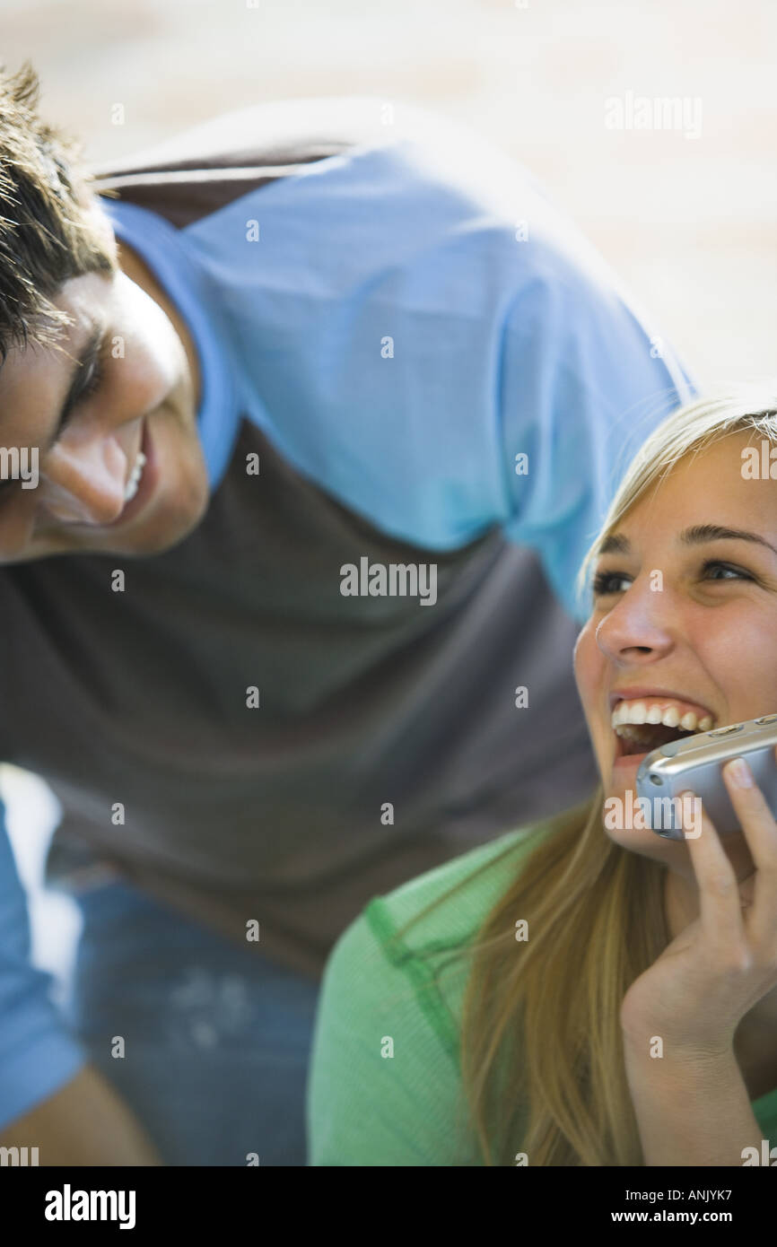 Close up of a young man bending over a young woman talking on a mobile phone Stock Photo