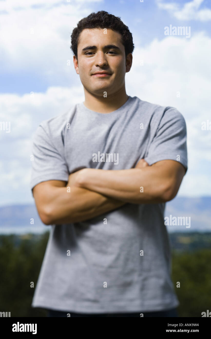 Portrait of a young man standing with his arms folded Stock Photo - Alamy