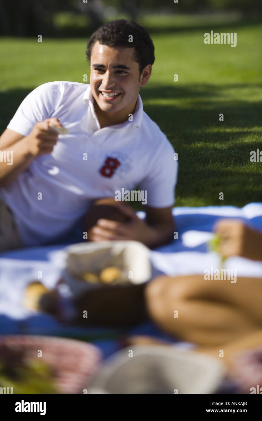 Young man lying on a picnic blanket in a park Stock Photo