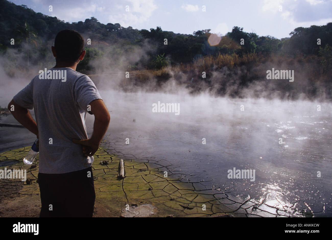 El Salvador. Man viewing pit of  volcanic steaming water near Ahuachapan Stock Photo