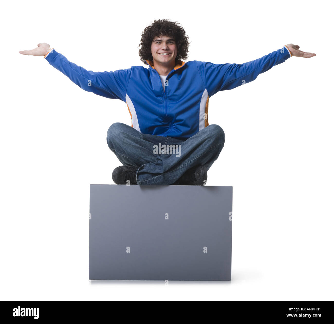 Portrait of a teenage boy sitting on a blank sign Stock Photo - Alamy