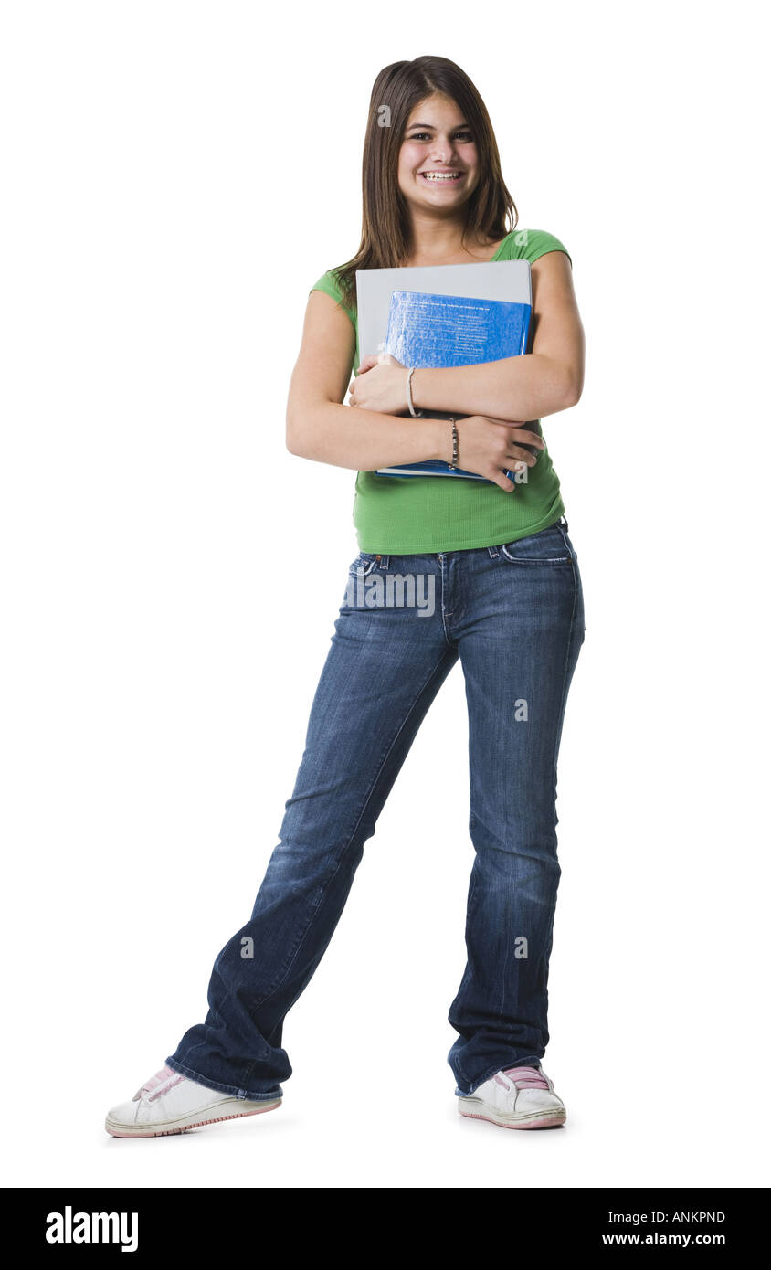Portrait of a teenage girl standing holding notebooks and smiling Stock ...