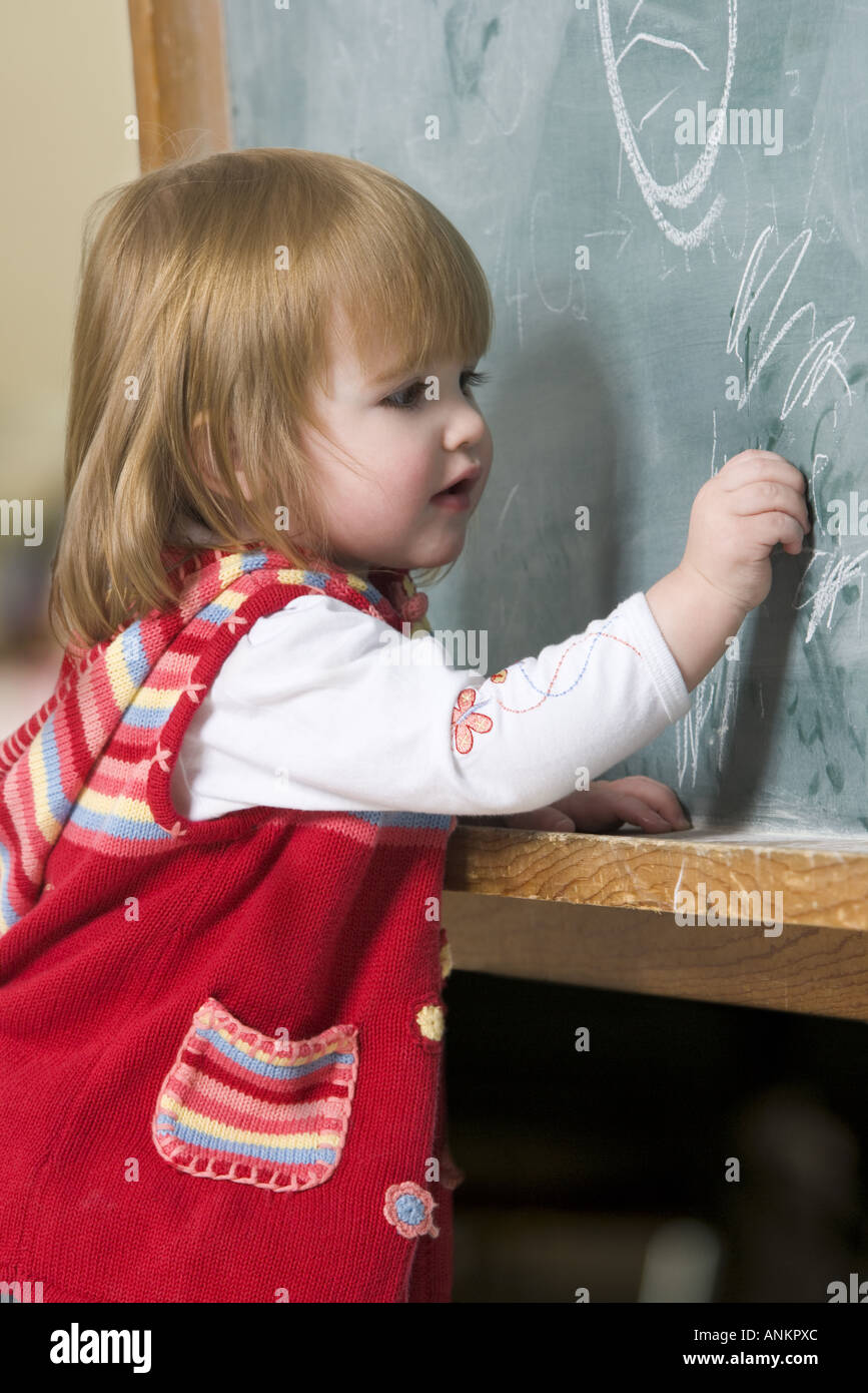 Profile of a baby girl writing on a blackboard Stock Photo Alamy