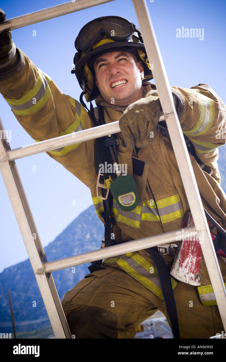 Low angle view of a firefighter climbing a ladder Stock Photo - Alamy