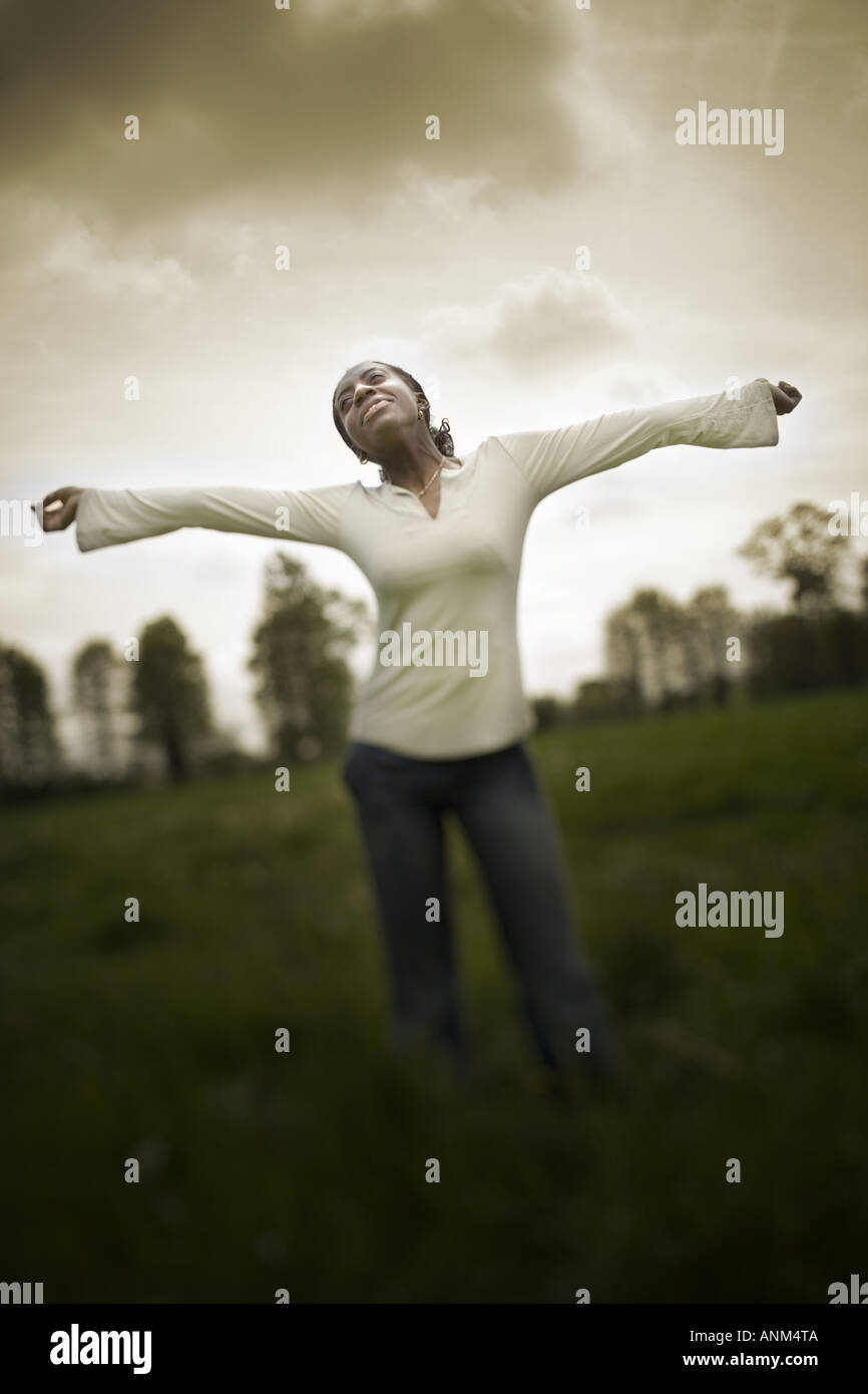 Teenage girl standing in a field with her arms outstretched Stock Photo ...