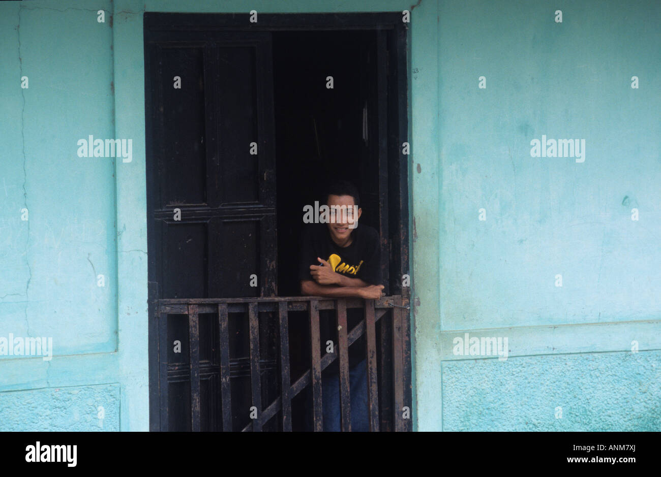 Boy in doorway of spanish style colonial house. Villa de los Santos, Peninsula de Azuero, Panama Stock Photo