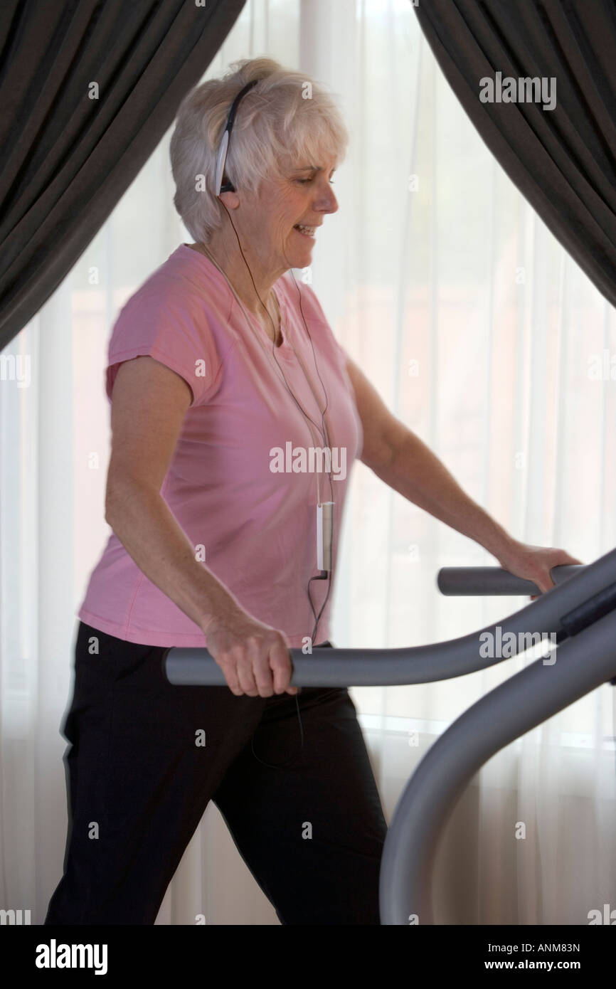 Senior woman works out on a treadmill mill Stock Photo