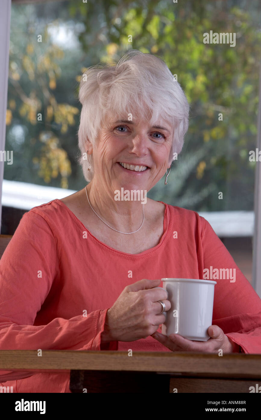 Happy senior woman with mug of coffee Stock Photo