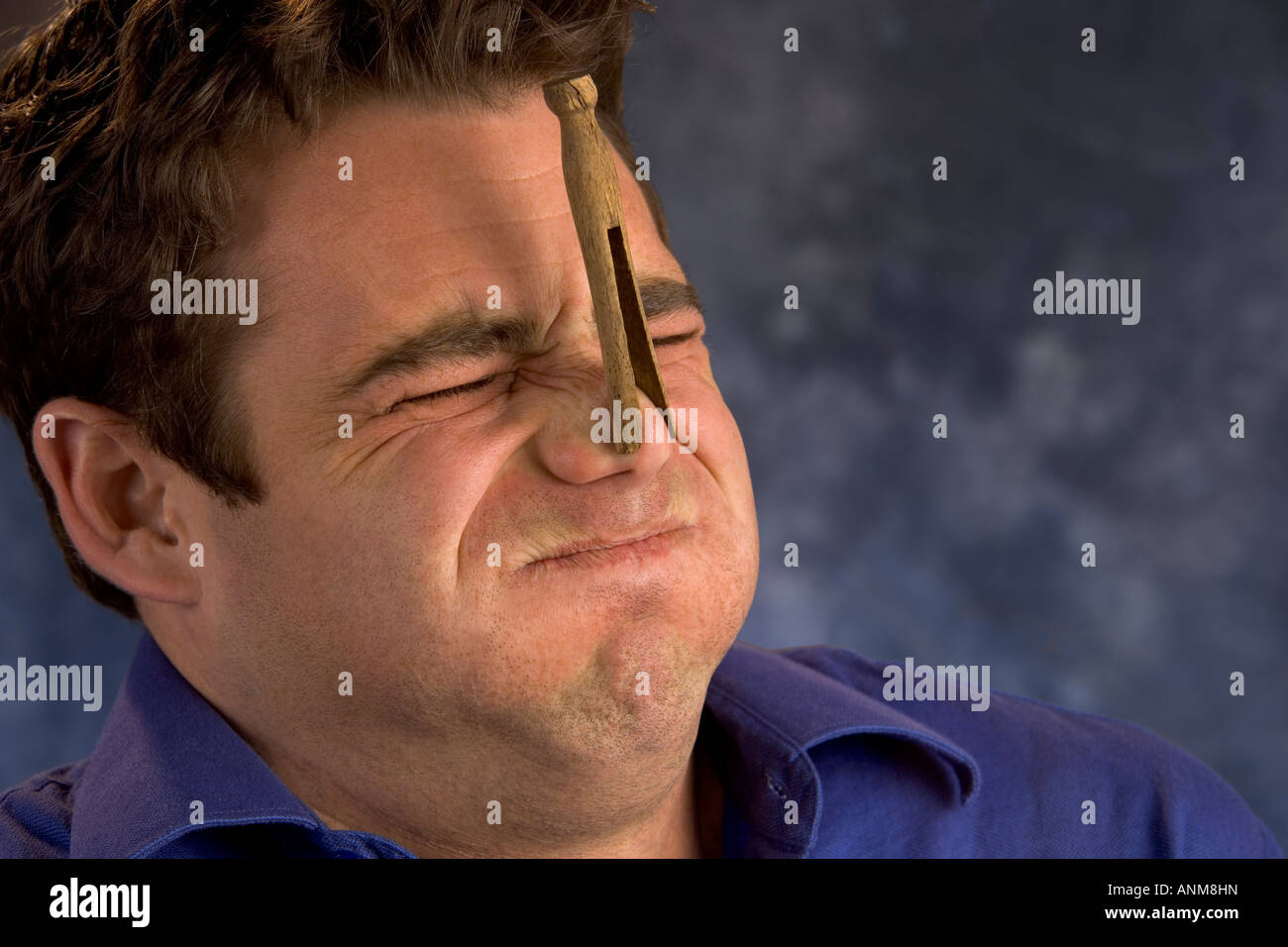 Man with old fashioned wooden clothes pin on his nose Stock Photo