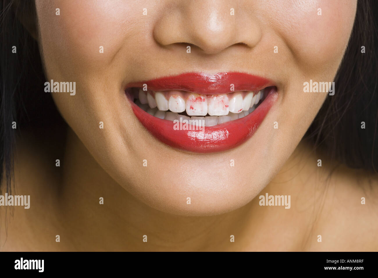 Close up of a woman s lips with lipstick on her teeth Stock Photo