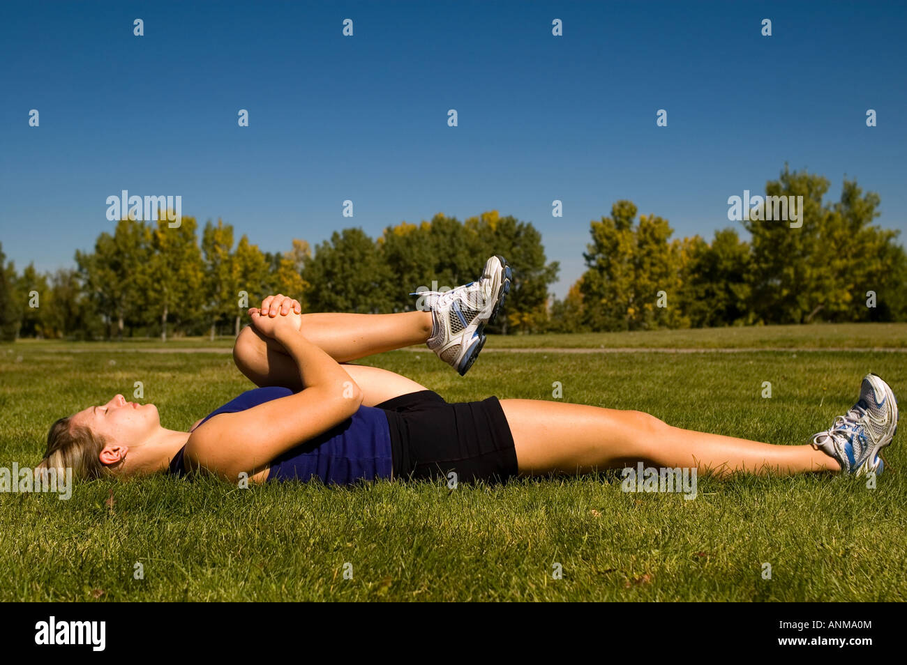 Young woman in a prone hamstring stretch Stock Photo
