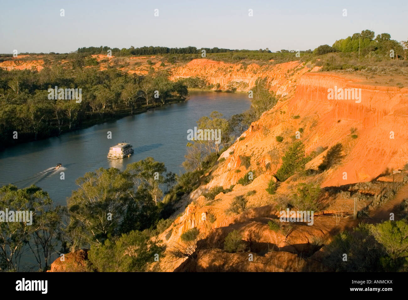 View a houseboat cruising past the red cliffs at Headings Cliffs on the