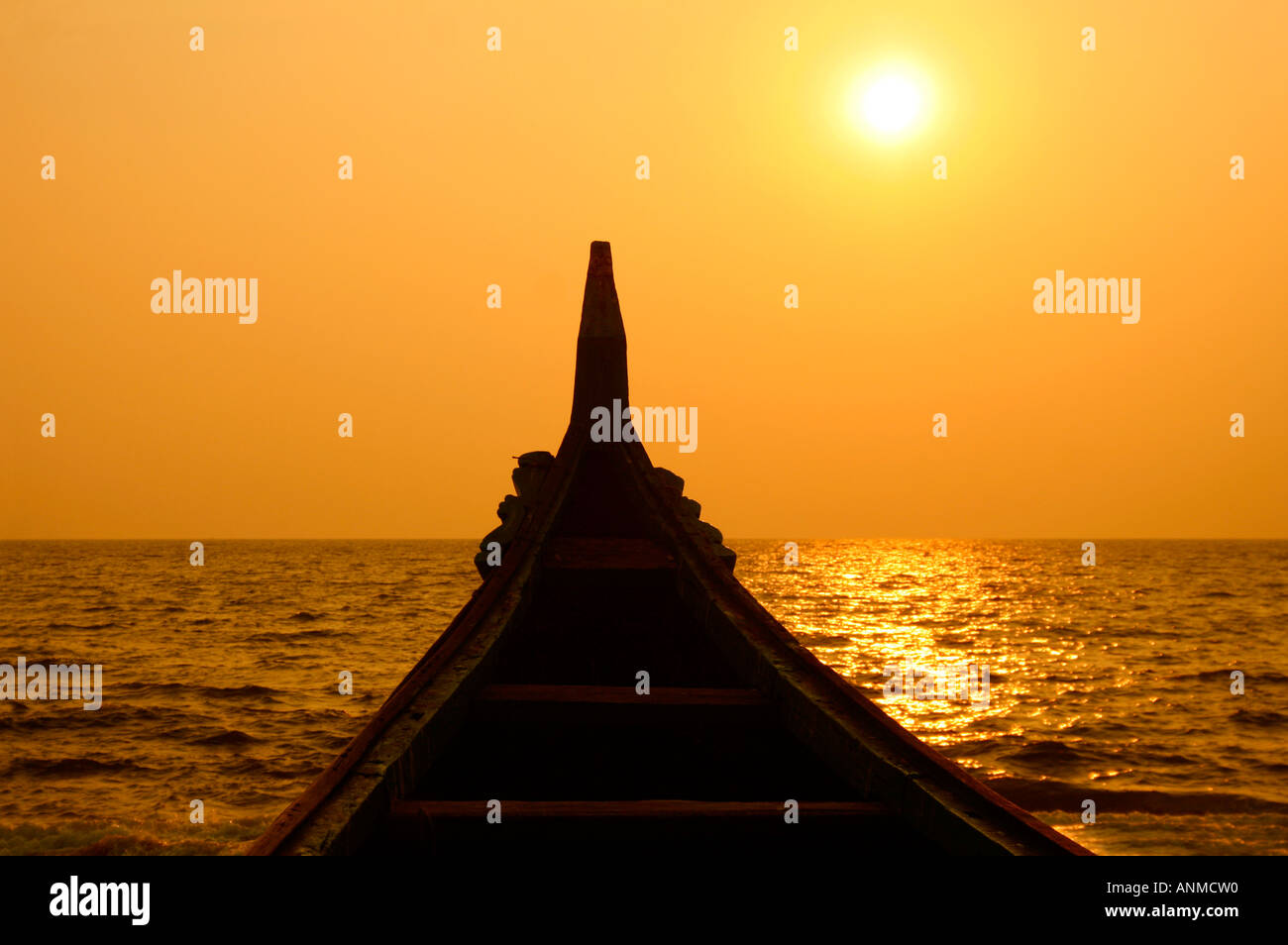 The helm of a boat in the background of the setting sun and sea Stock Photo
