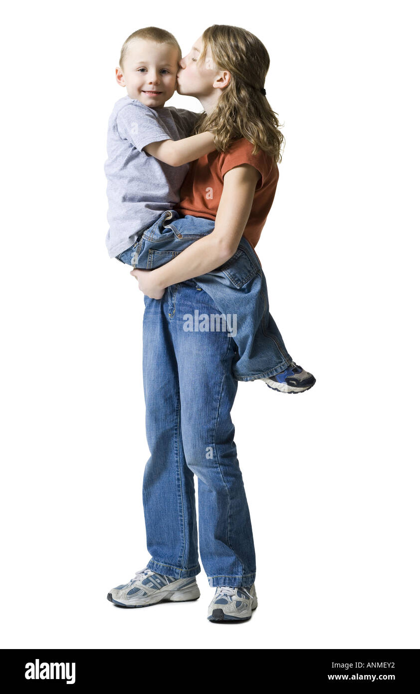 Profile of a sister kissing her brother Stock Photo