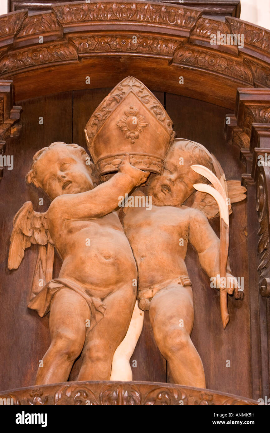 UK London Saint Pauls Cathedral choir Bishops seat decorated by Grinlings Gibbons carvings cherubs holding mitre detail Stock Photo