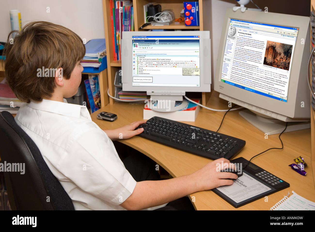 11-year-old-school-boy-doing-home-work-on-a-two-screen-pc-ANMKDW.jpg