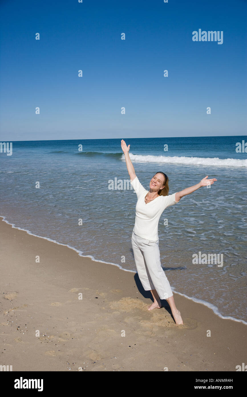 Woman with arms raised at beach Stock Photo