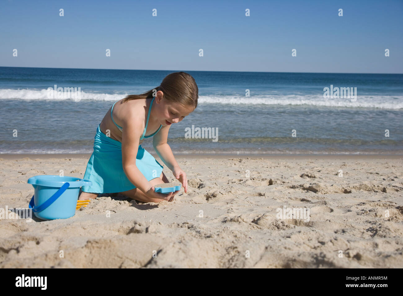 Girl kneeling in the sand hi-res stock photography and images - Alamy