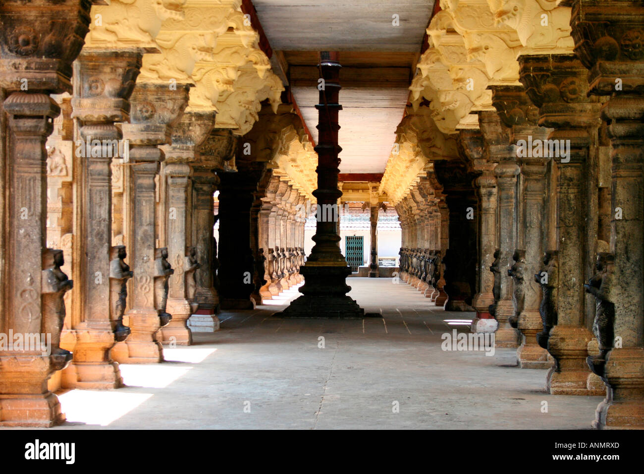 A long passage lined by stone pillars on both sides and a pillar in the middle in a temple in