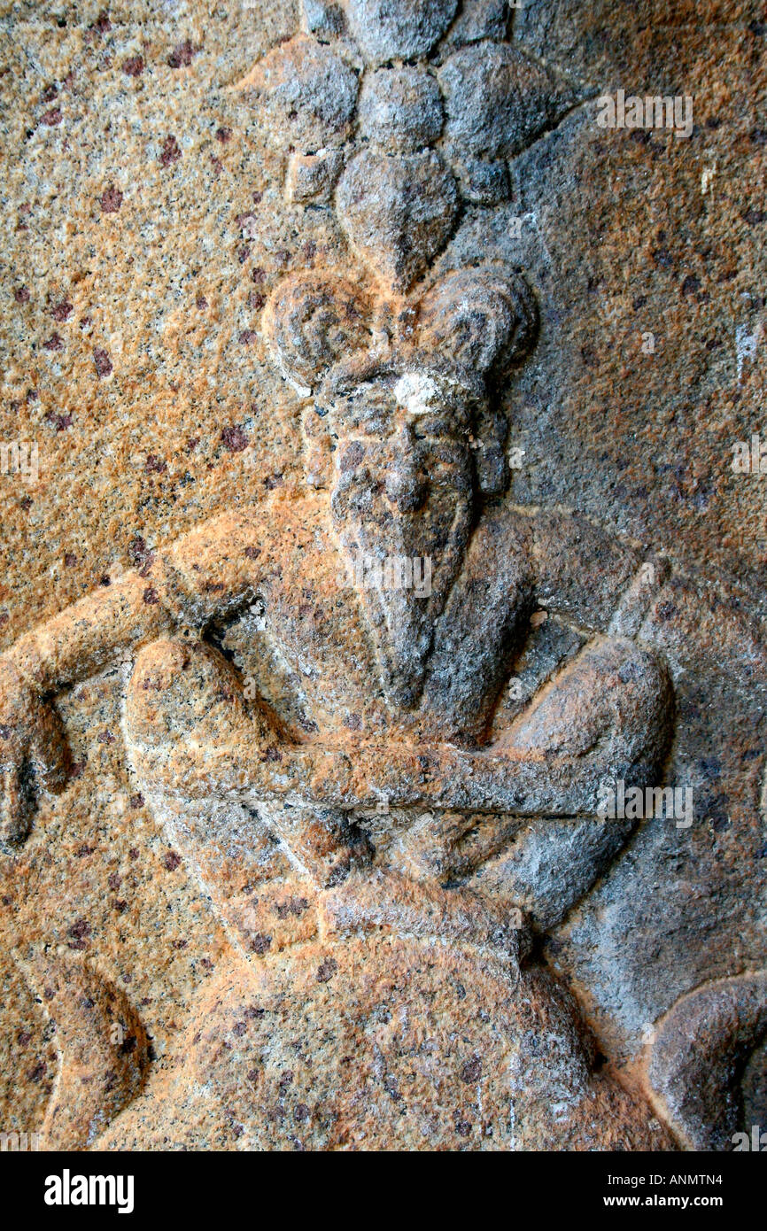 Sculpture on stone of a human figure with the face of an animal Stock Photo