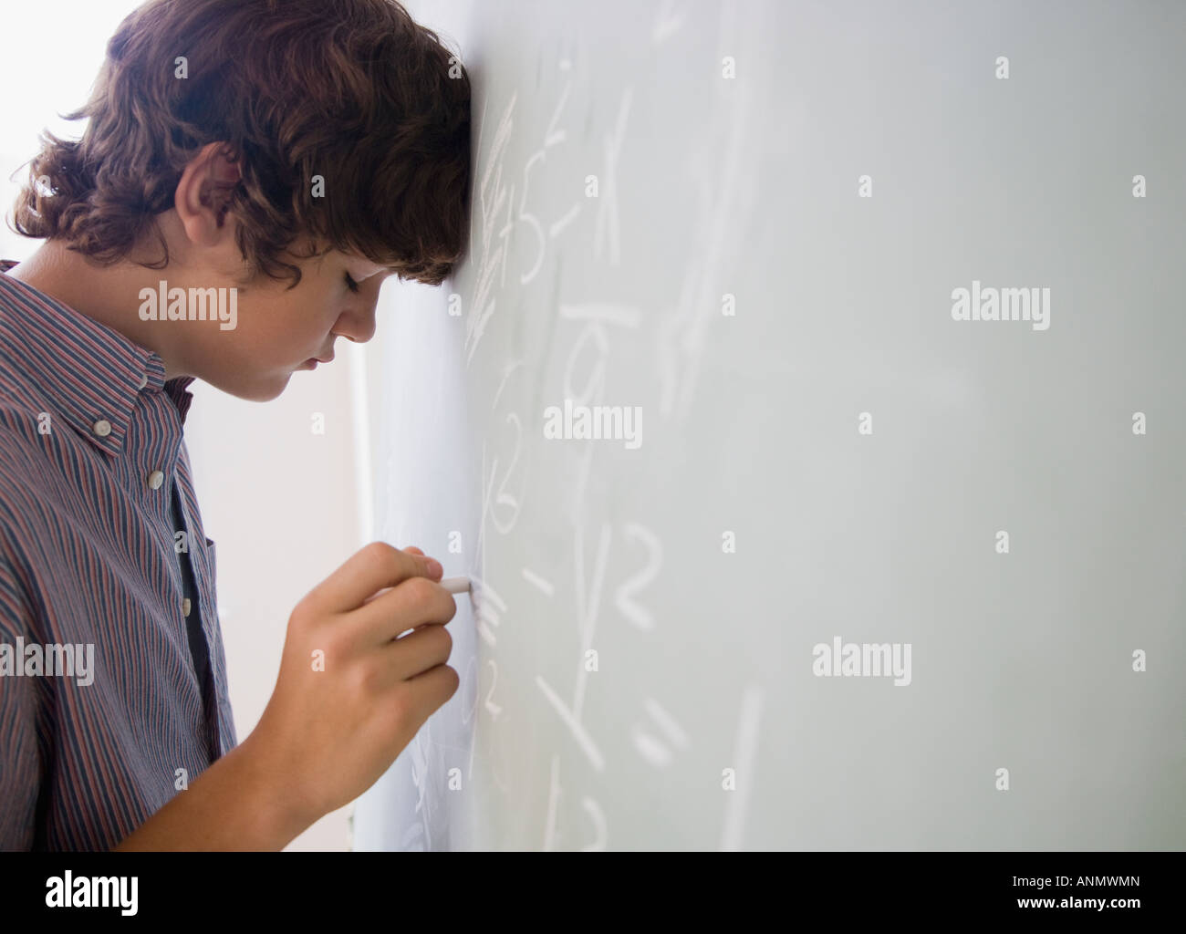 Teenaged boy writing math equations on blackboard Stock Photo - Alamy