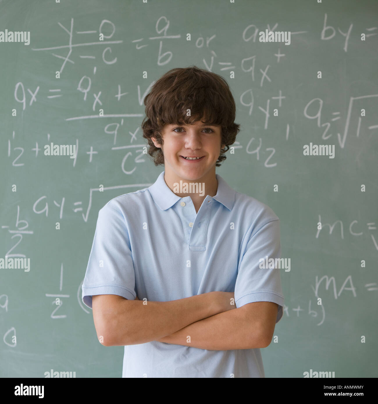 Teenaged boy in front of blackboard with math equations Stock Photo