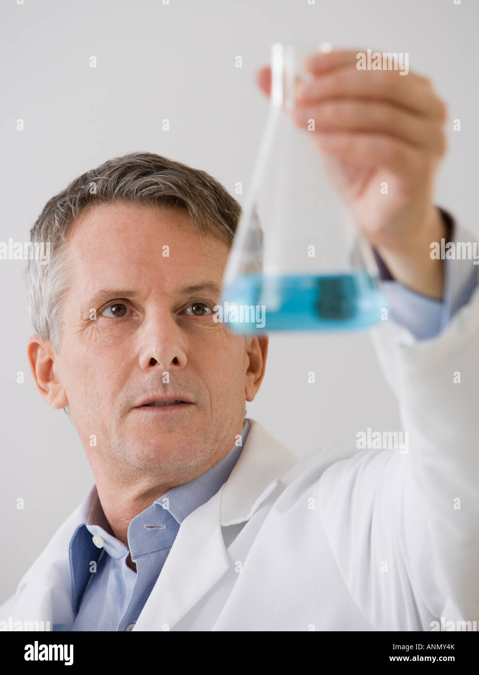 Male scientist looking at beaker Stock Photo Alamy