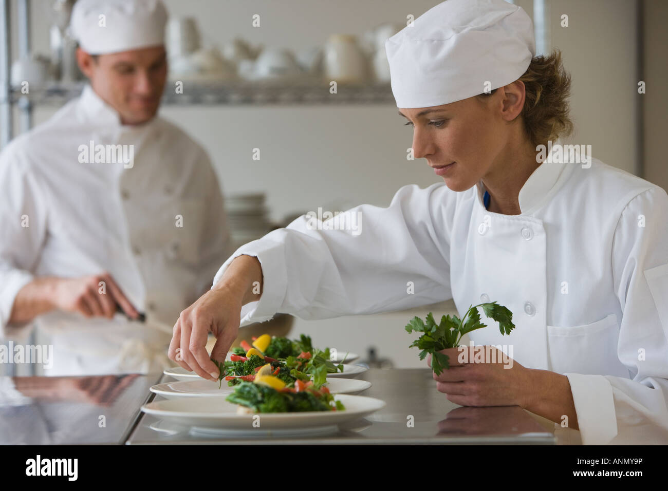Female chef plating food Stock Photo