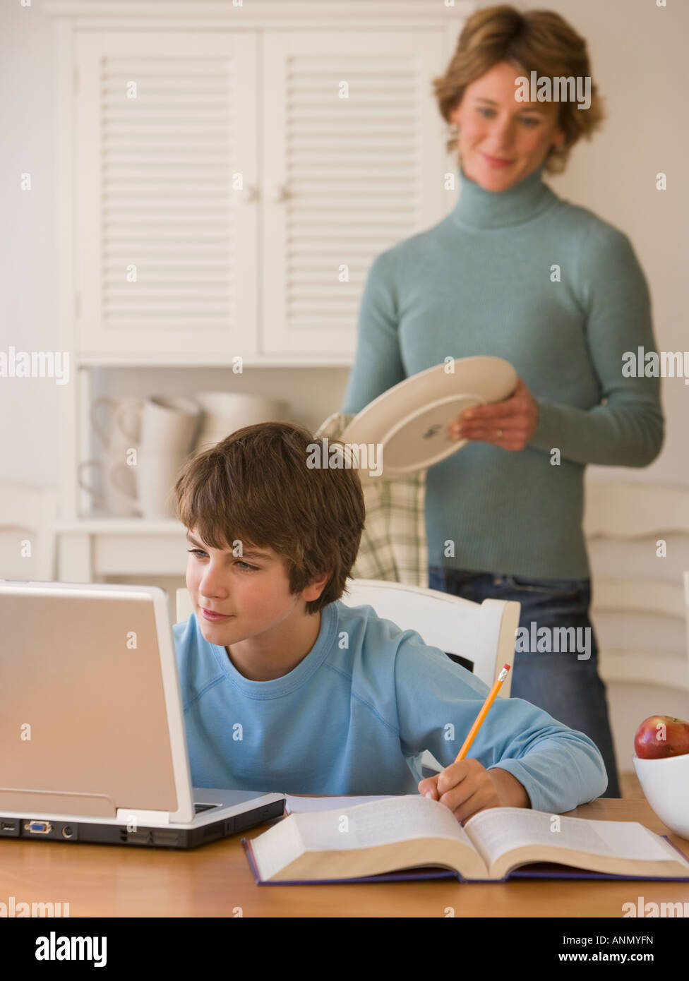 Boy doing homework with laptop Stock Photo