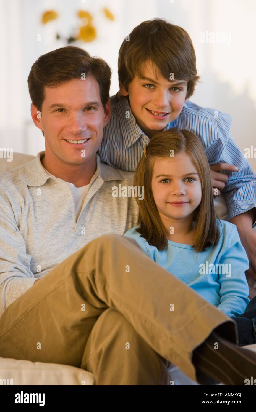 Father and children sitting on sofa Stock Photo