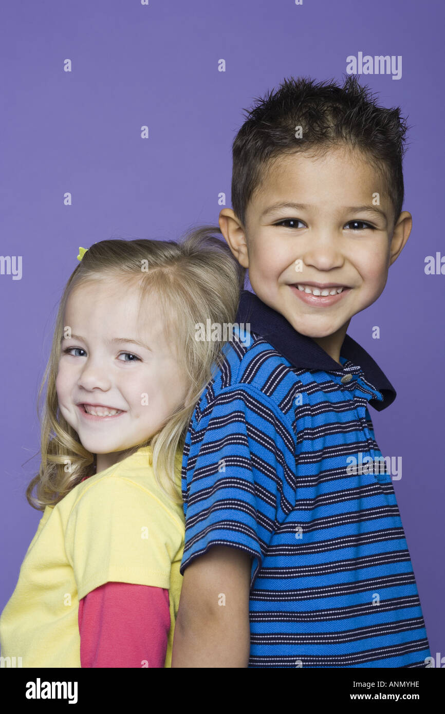 Portrait of a girl and a boy standing back to back Stock Photo - Alamy
