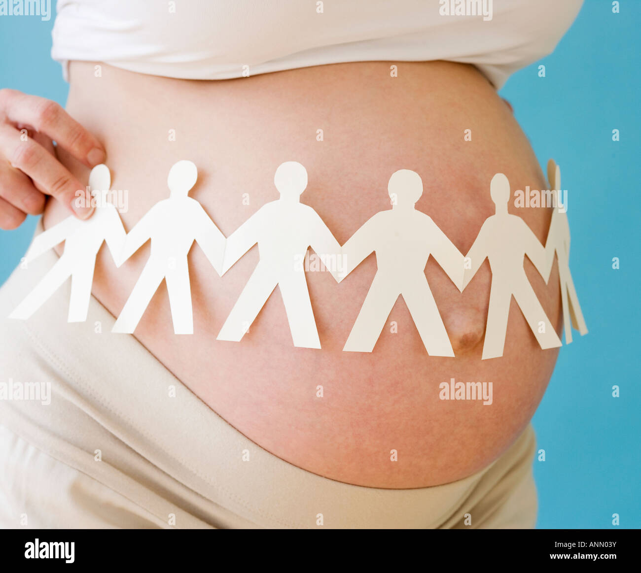 Pregnant woman holding paper dolls around belly Stock Photo Alamy