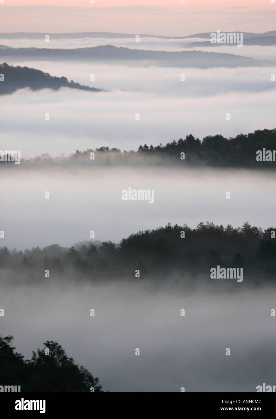 A magical landscape of black wooded spurs and mist filled valleys in France Stock Photo