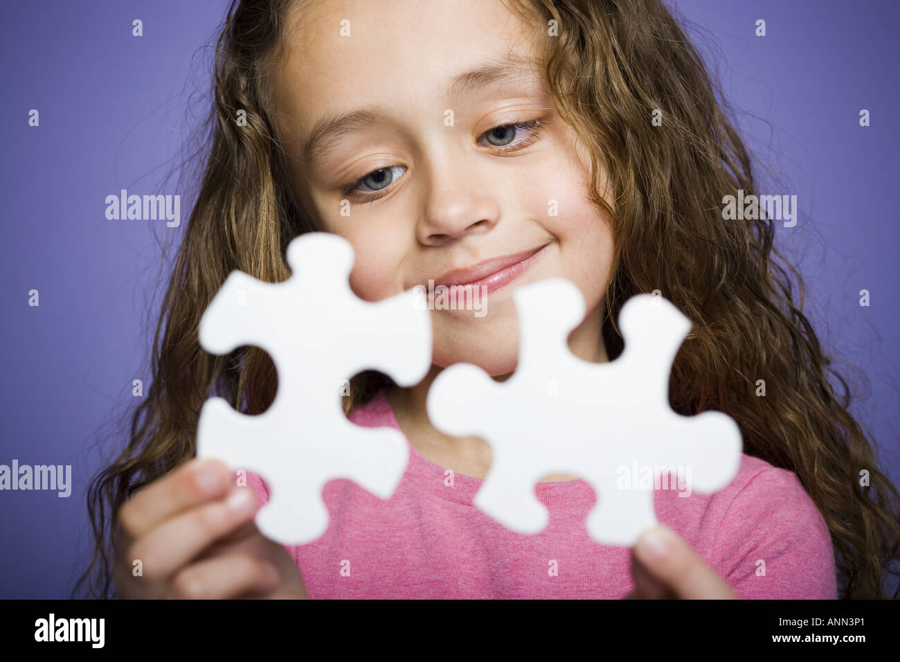 Close up of a girl holding a puzzle piece Stock Photo