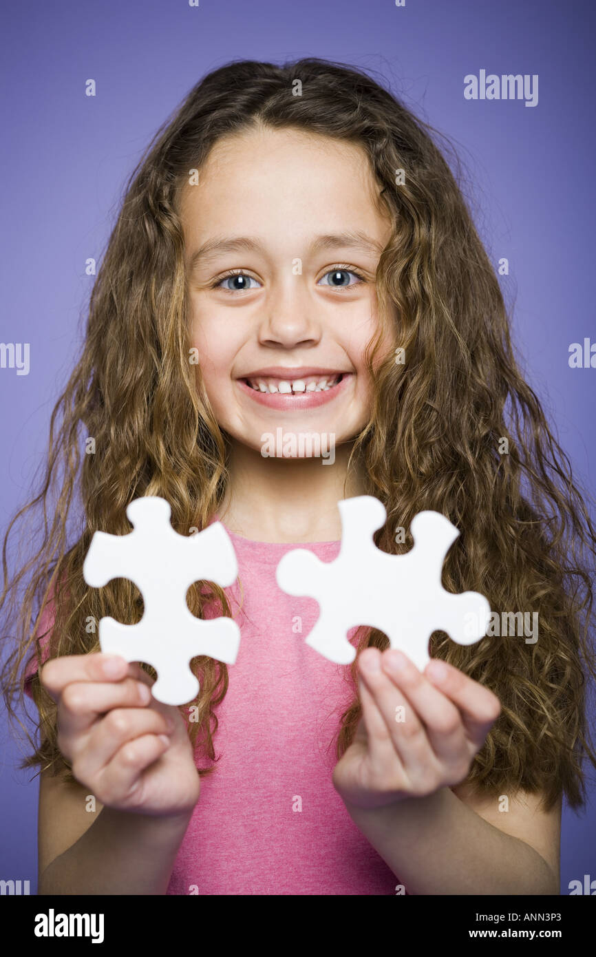 Portrait of a girl holding a puzzle piece Stock Photo