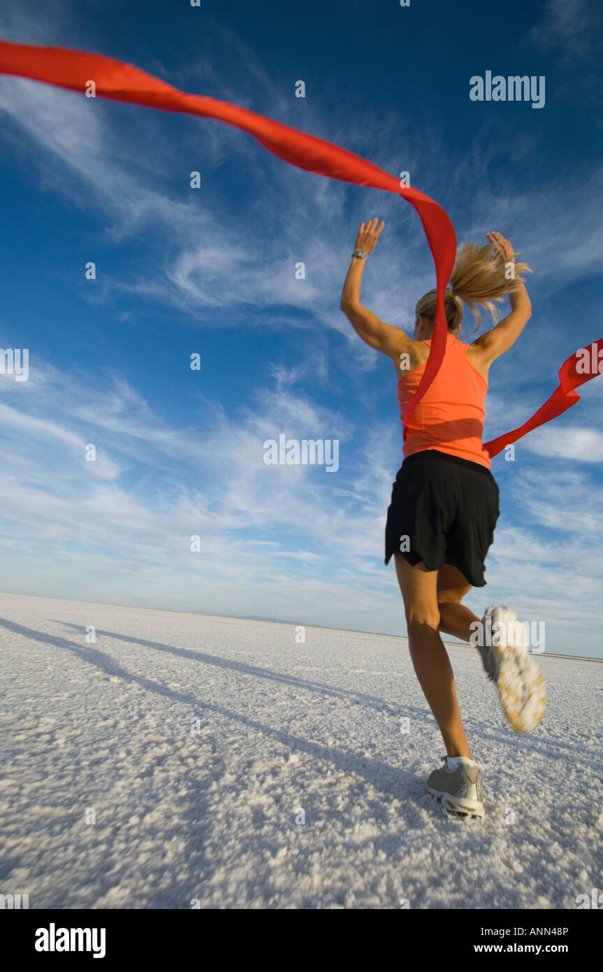 Woman running across finish line, Utah, United States Stock Photo