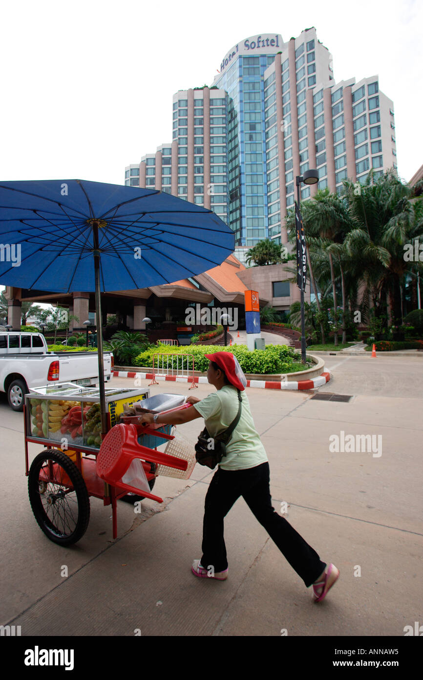 Lady with a trolley loaded with sliced fruit walking past the entrance at Sofitel Hotel Khon Kaen Stock Photo