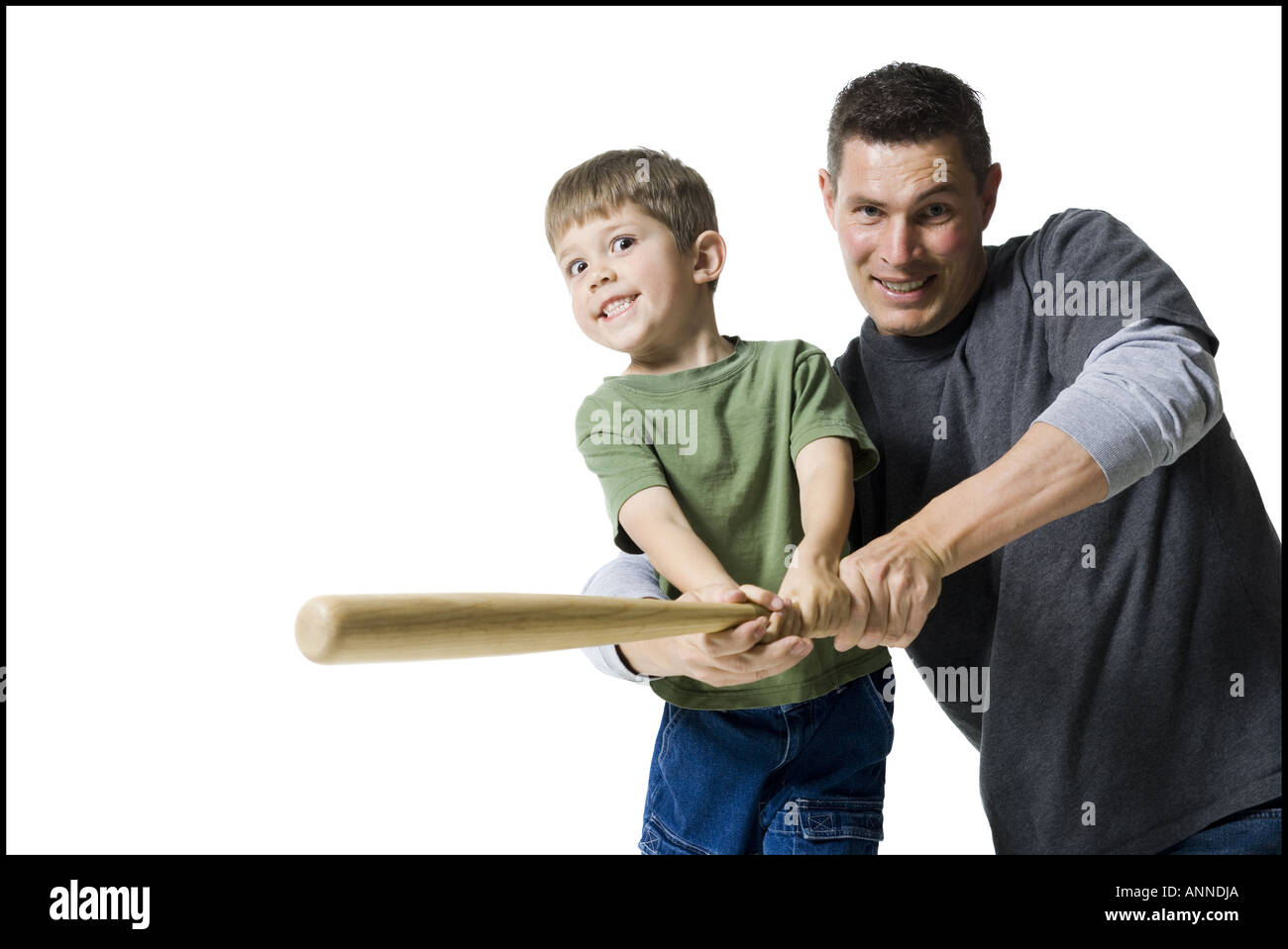 Portrait of a father teaching his son how to swing a baseball bat Stock